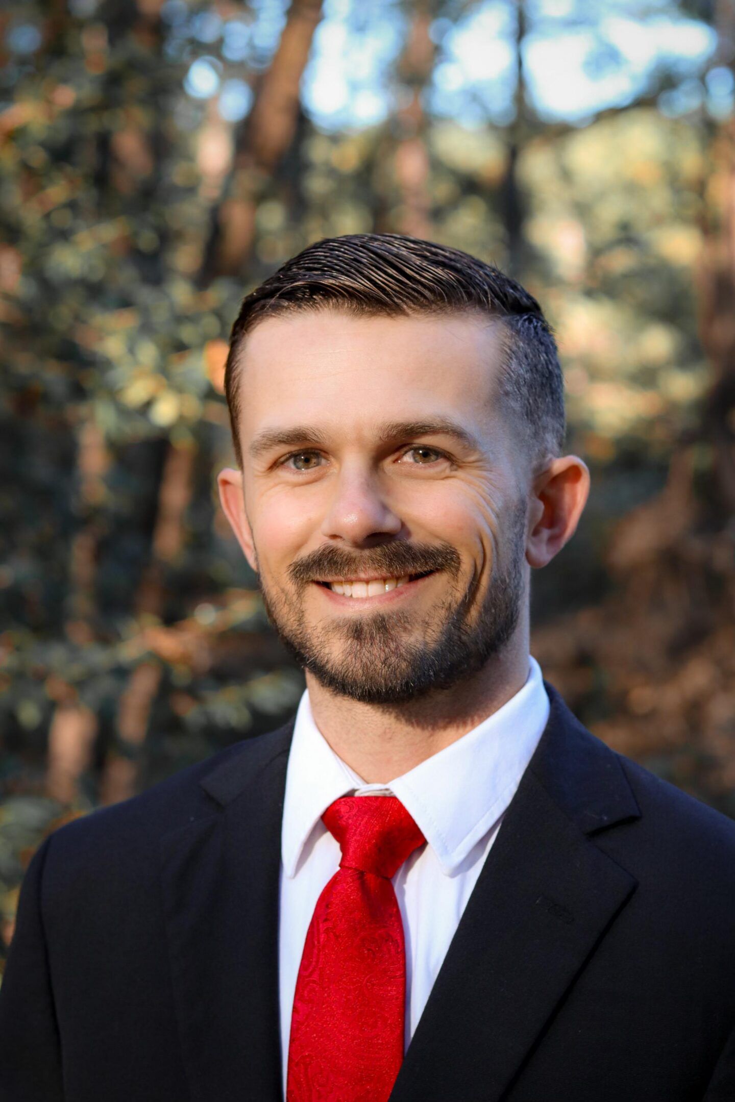 Smiling man in suit with red tie